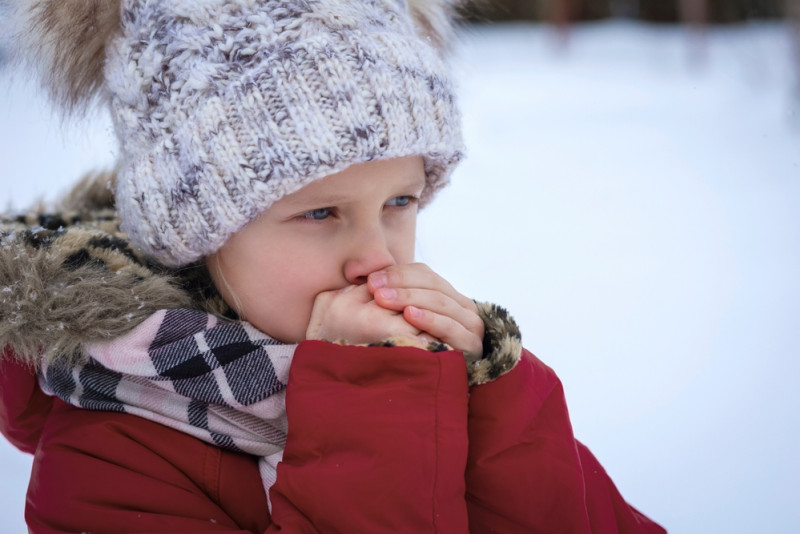 Enfant qui souffle sur ses doigts froids
