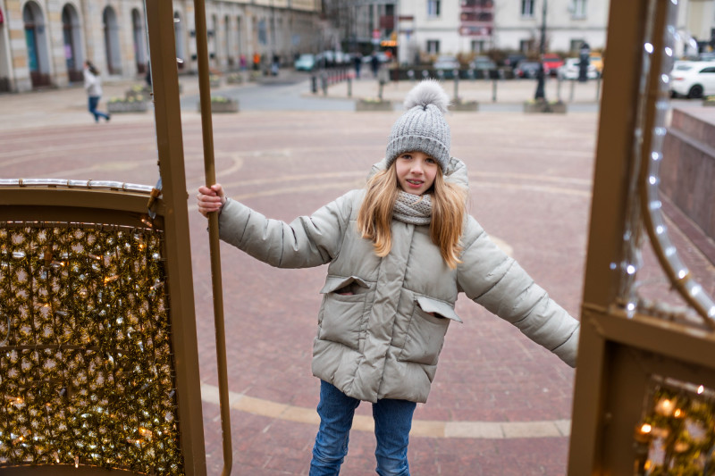 Une petite fille dehors avec un manteau