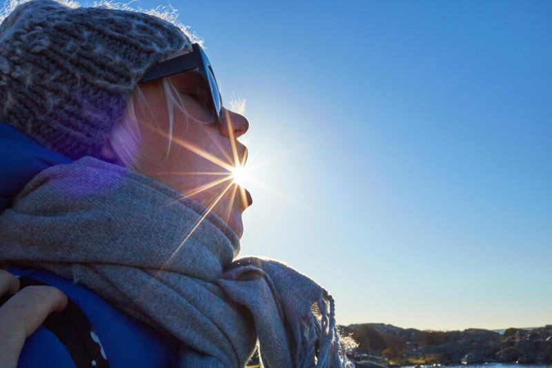 Femme avec soleil et ciel bleu