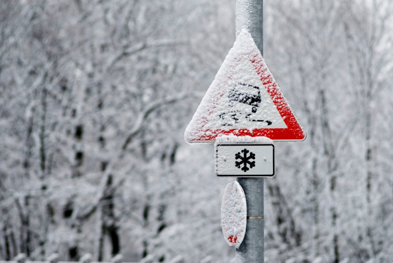 Panneau attention verglas couvert de neige