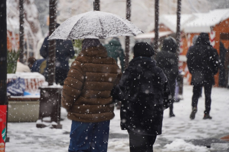 Des personnes marchent sous la neige