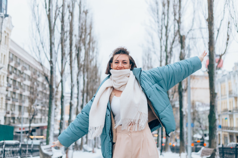 Une femme écarte les bras et semble heureuse