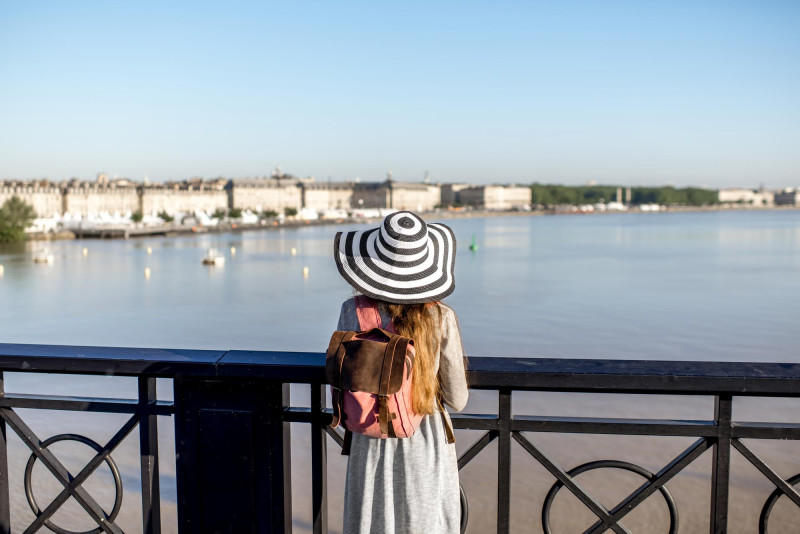 Une femme accoudée devant un fleuve