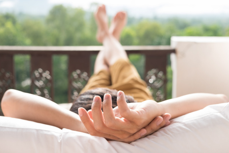 Un homme fait la sieste sur son balcon