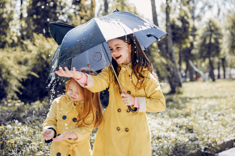 Des fillettes jouent sous la pluie