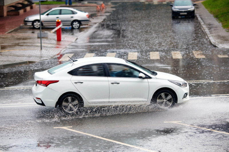 Une voiture roule sur une route pluvieuse