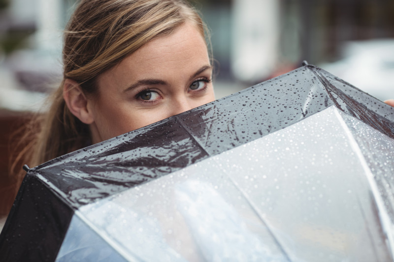 Femme cachée derrière un parapluie