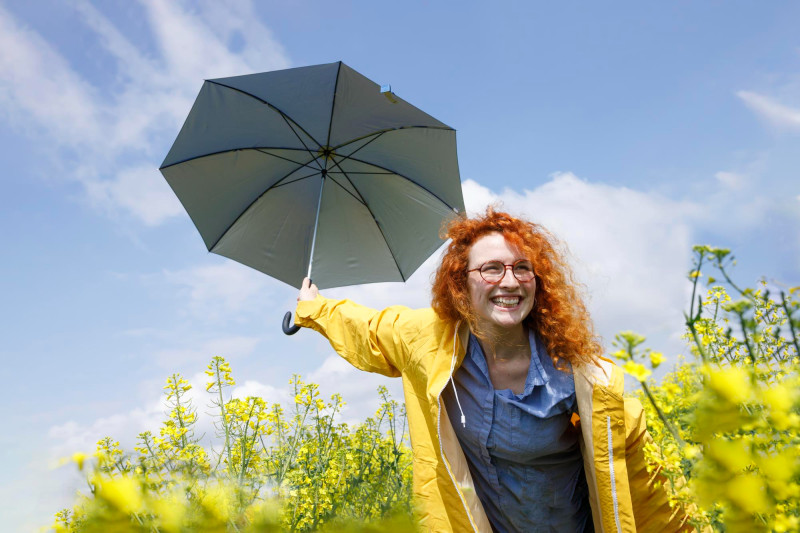 Une femme avec un parapluie dans un champ en fleurs