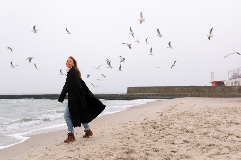 Une femme sur la plage avec des oiseaux