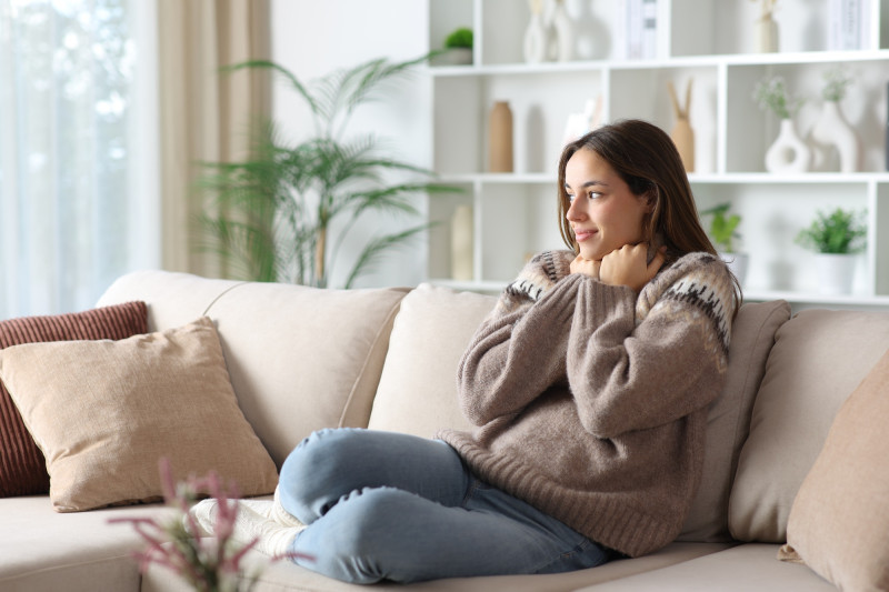 Une femme dans son canapé avec un pull