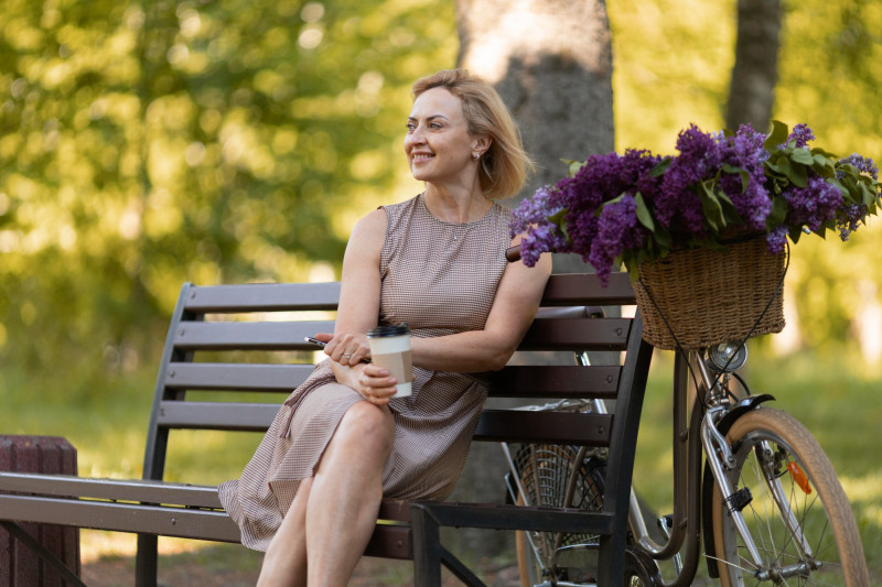 Une femme assise dans un parc au soleil