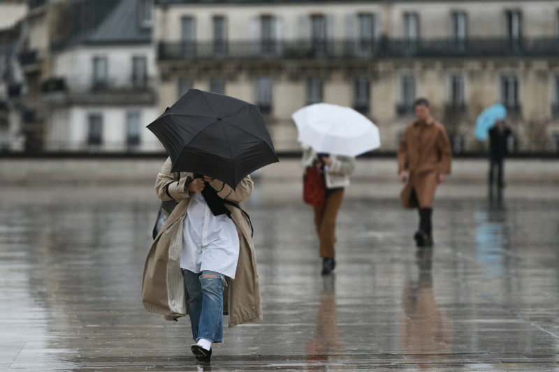 Des piétons marchent avec un parapluie