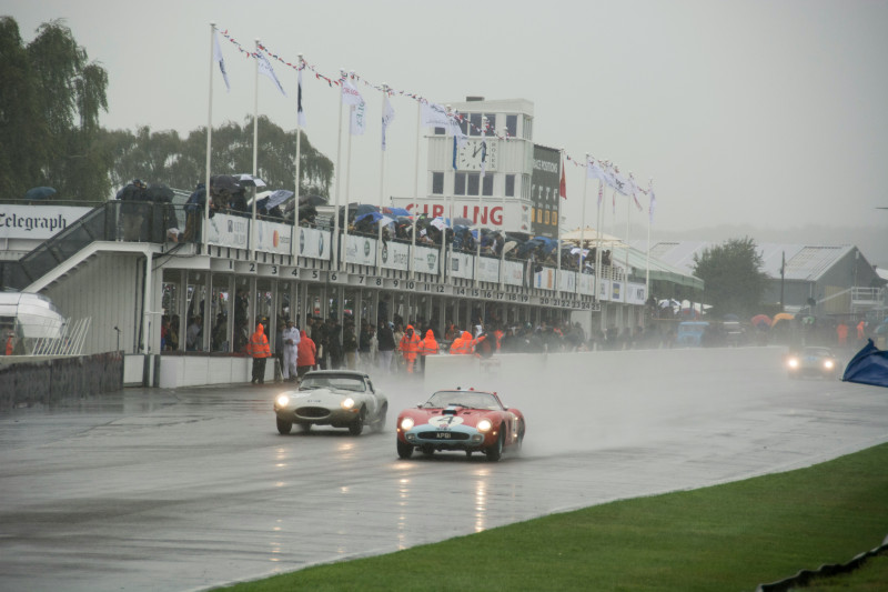 two cars driving down a wet road in the rain