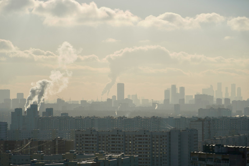 a view of a city with smoke coming out of it