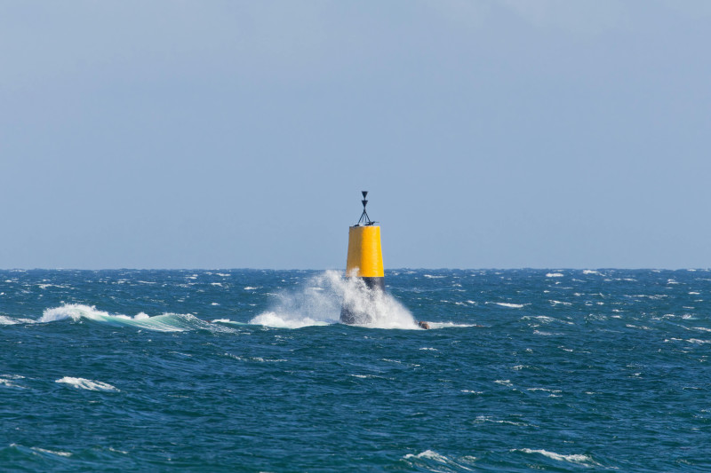 Une bouée jaune vif au milieu des vagues déferlantes de l'océan Atlantique, au large des côtes bretonnes.