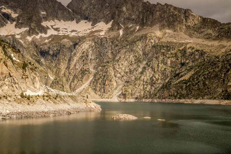 Vue majestueuse sur les montagnes escarpées et le lac paisible d'Aragnouet, en France.