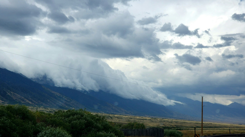 Dramatic storm clouds roll over distant mountains