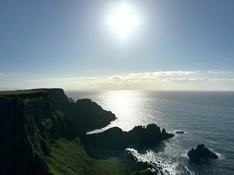 Sunny coastal cliffs of the Causeway Coast overlooking shimmering ocean, Northern Ireland, United Kingdom, June 2025