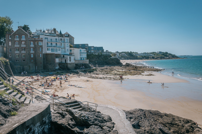 Une journée d'été pittoresque à la plage de Dinard, en France, mettant en valeur une architecture charmante et une scène côtière vibrante.
