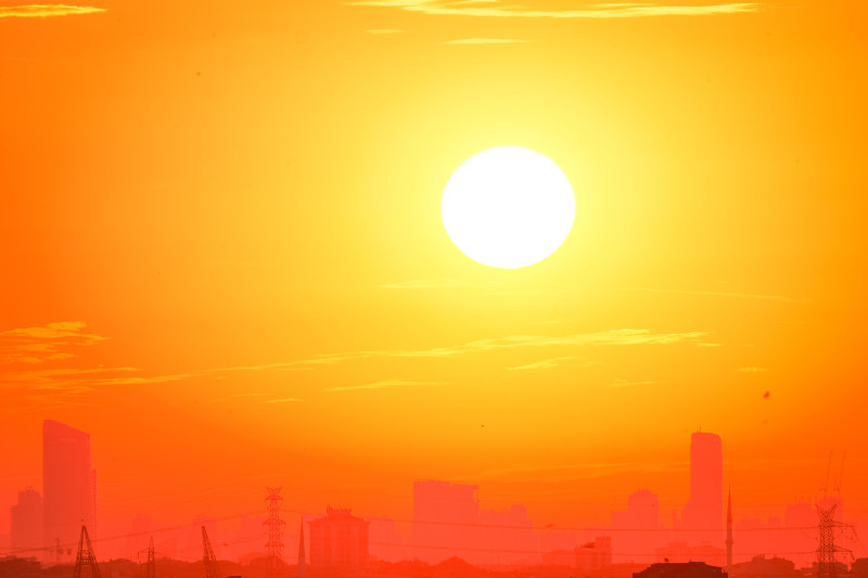 Une silhouette de la ville contre un ciel de coucher de soleil orange vif.