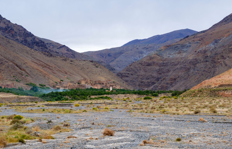 Une vue pittoresque d'un village isolé niché dans une vallée sèche du désert entourée de montagnes.