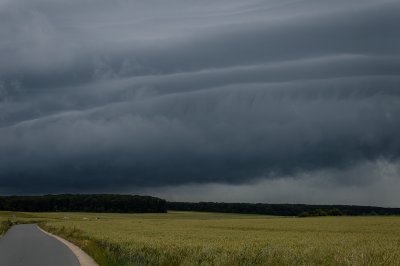 Image saisissante de nuages ​​d'orage menaçants planant au-dessus d'un paysage rural.