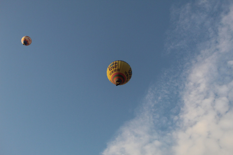 Des montgolfières vibrantes s'élevant dans un ciel bleu clair, symbolisant la liberté et l'aventure.