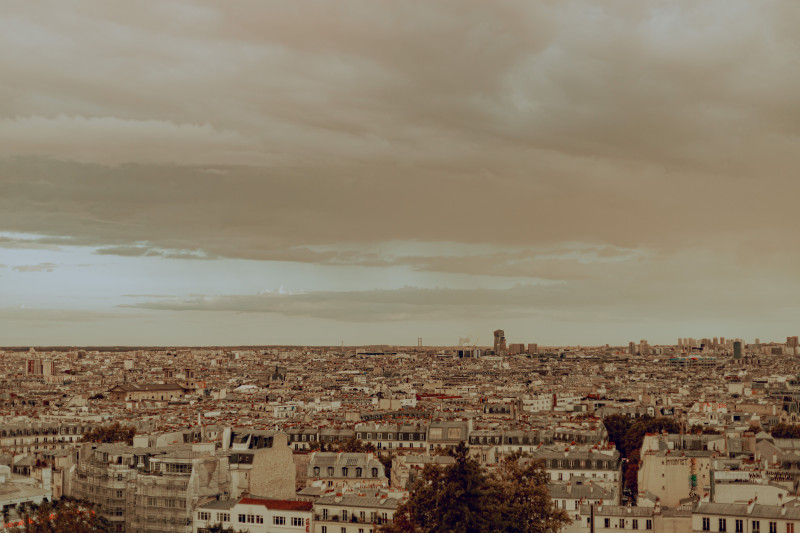 Vue panoramique de Paris sous un ciel couvert, capturant le paysage urbain en automne.