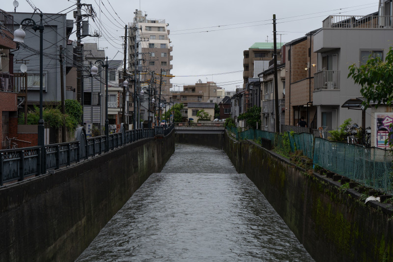 Vue d'un canal bordé d'immeubles résidentiels dans un quartier de Tokyo.