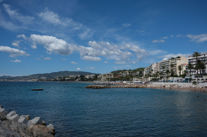 Vue panoramique d'une ville côtière avec un ciel bleu clair et une côte vibrante.