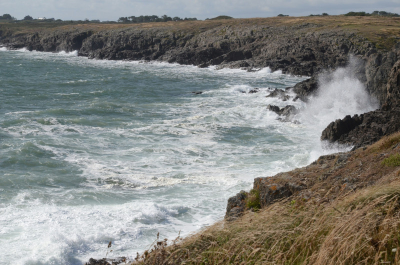 a large body of water next to a rocky cliff
