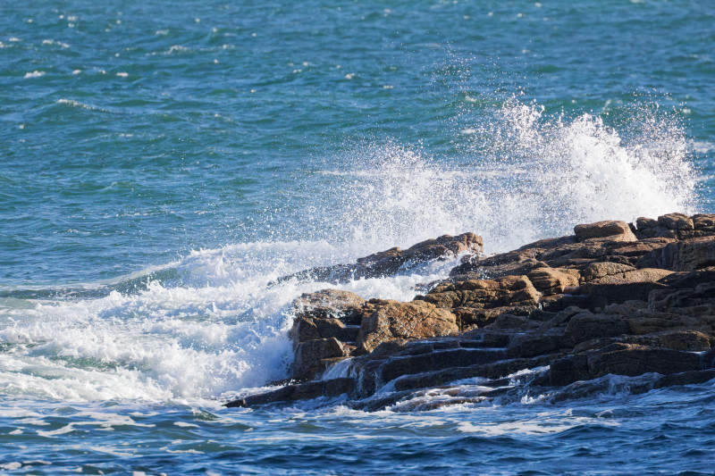Vagues océaniques dynamiques s'écrasant contre les rochers escarpés de Ploemeur, en Bretagne, France.