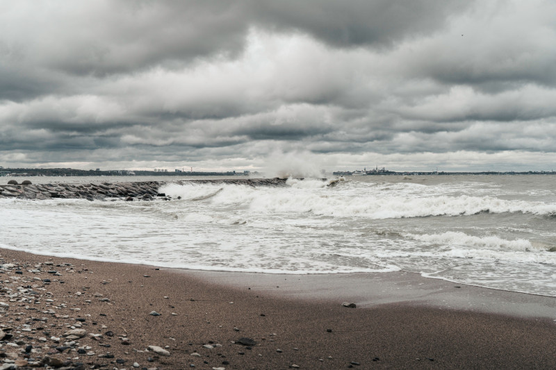 Une vue maussade et dramatique de vagues orageuses s'écrasant sur une plage estonienne sous un ciel couvert.
