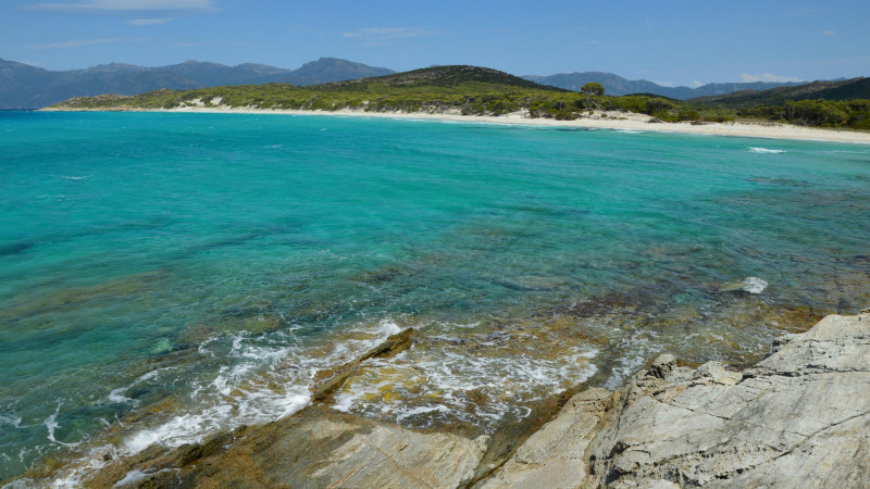 Beautiful turquoise sea, sandy beach, and rocky coast