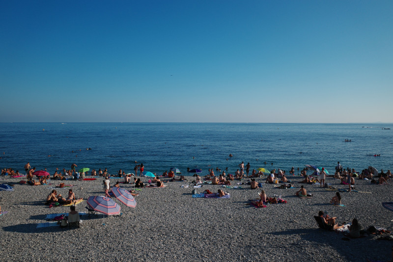 Une scène de plage animée à Nice, en France, avec des baigneurs et des parasols par une belle journée d'été.