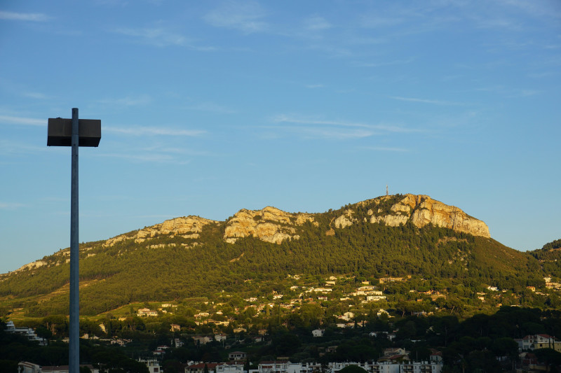 Sunlit mountain range with houses and clear blue sky