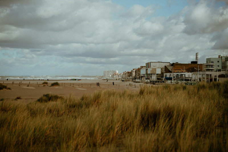 Beach town with grassy dunes and cloudy sky