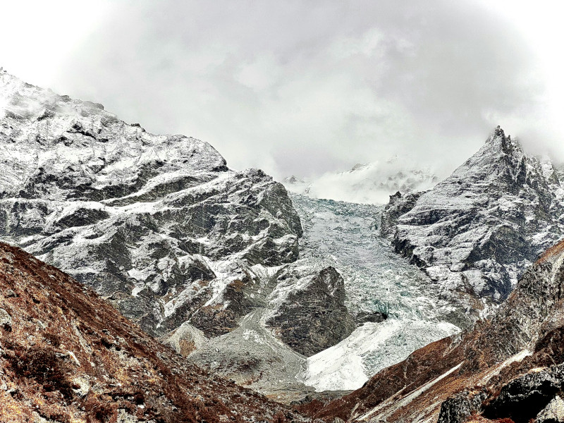 A mountain range covered in snow and clouds
