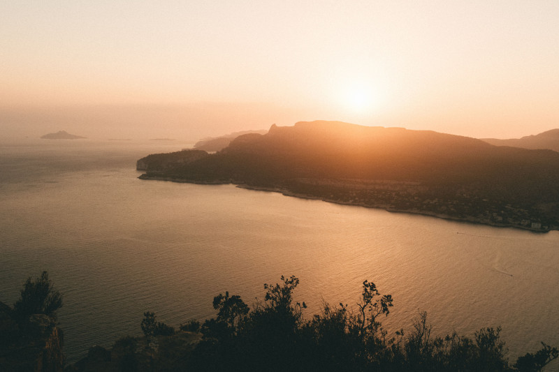Vue scénique du coucher de soleil sur la Côte de Cassis, Provence, avec une atmosphère chaude et sereine.