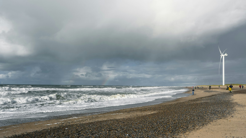 Wind turbine on a beach with choppy waves