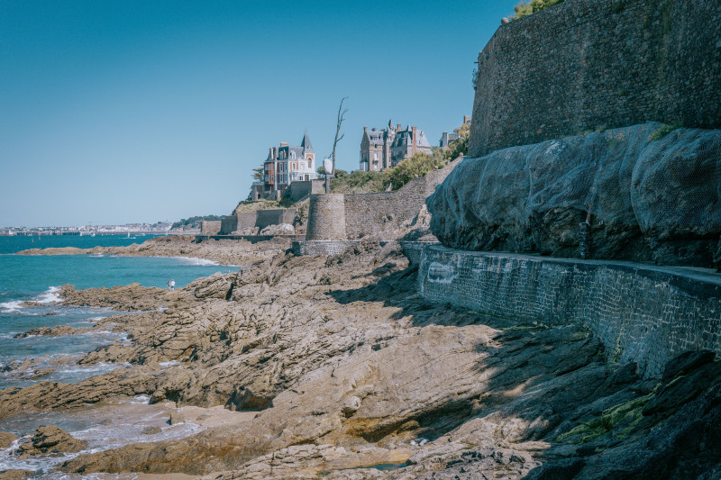 Explorez la magnifique côte rocheuse et l'architecture historique de Dinard, France, sous un ciel d'été dégagé.