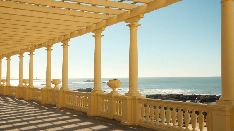 Colonnade majestueuse en bord de mer à Porto, au Portugal, sous un ciel d'un bleu limpide.