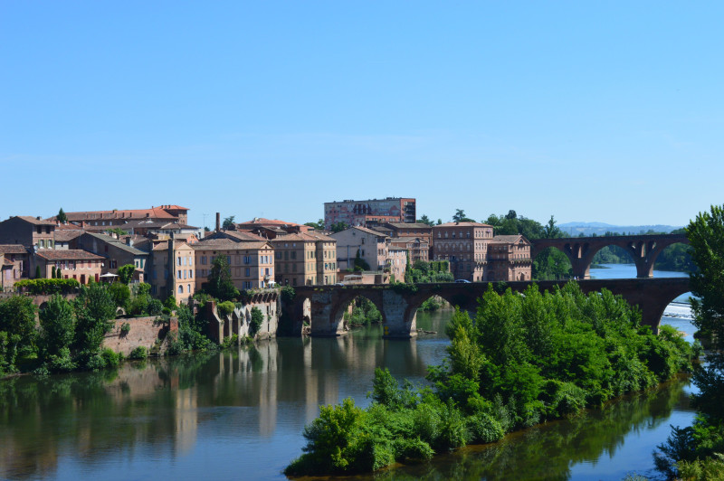 Vue charmante de la vieille ville d'Albi avec un pont de pierre se reflétant dans la rivière.
