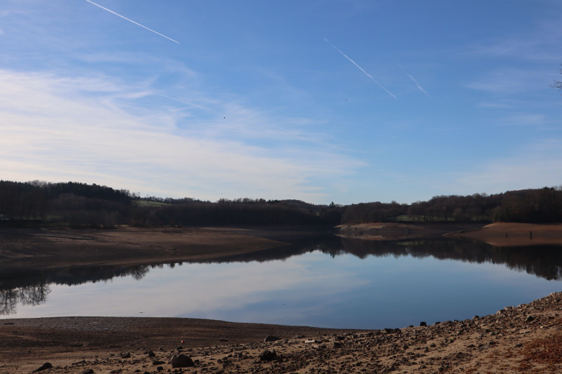 Paysage lacustre serein avec un ciel dégagé, parfait pour les passionnés de nature.
