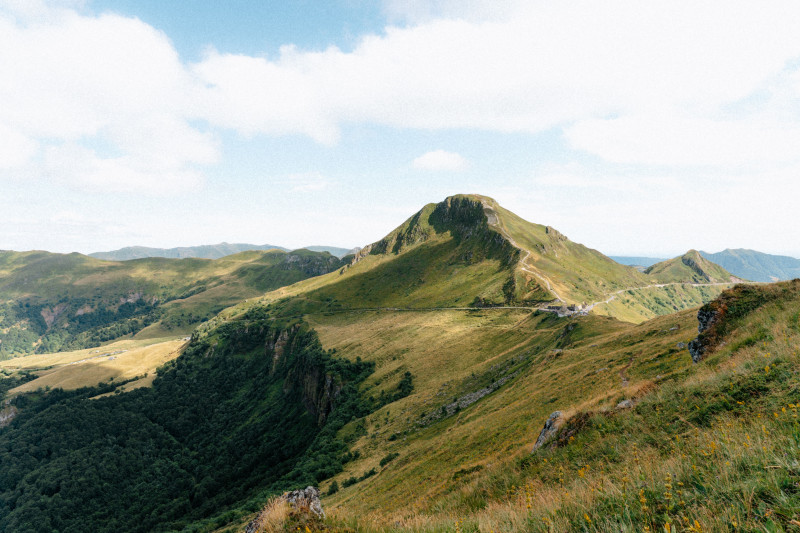 Vue imprenable sur les montagnes verdoyantes d'Auvergne-Rhône-Alpes, France sous un ciel d'été clair.
