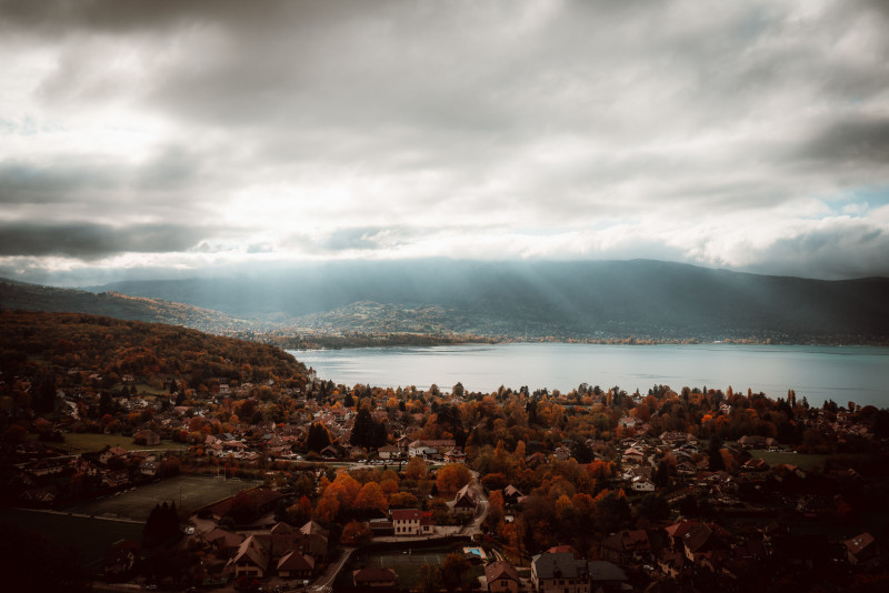 Vue aérienne à couper le souffle du lac d'Annecy avec son feuillage d'automne et ses nuages spectaculaires.