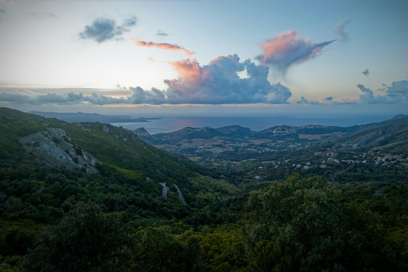 Mountain valley with distant ocean at sunset