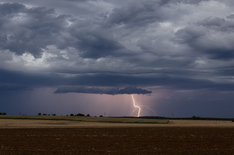 Image saisissante d'un orage au-dessus des champs en France, illustrant la puissance de la nature.