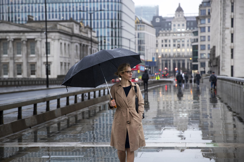 Femme se promenant dans la ville pendant qu'il pleut