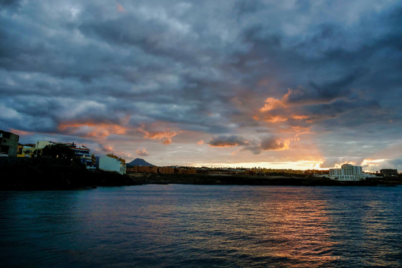Coucher de soleil sur l'eau sous un ciel assombri dans les îles Canaries, Espagne